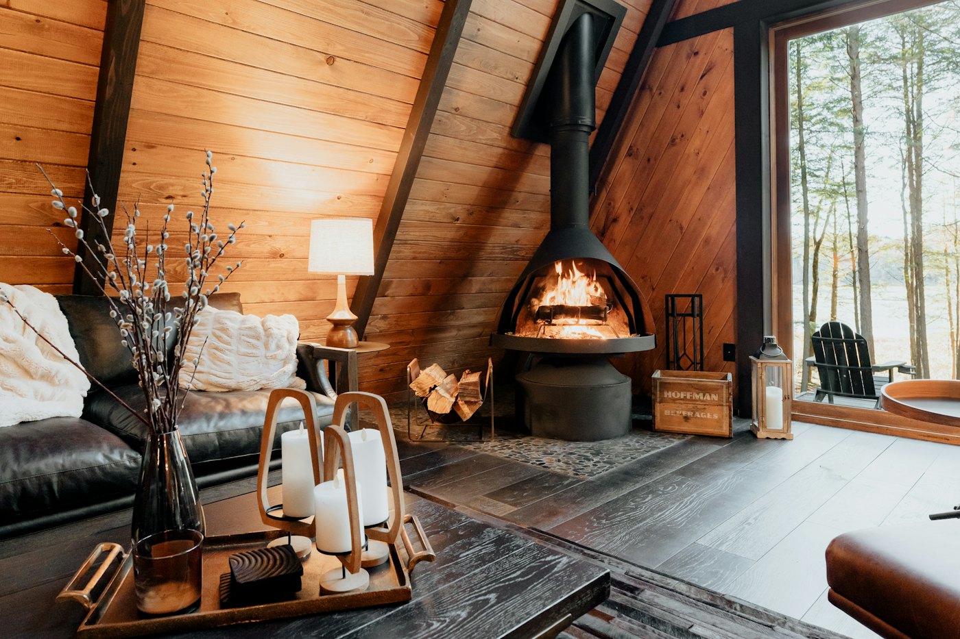 Lounge with a round black wood stove, leather sofa and candles