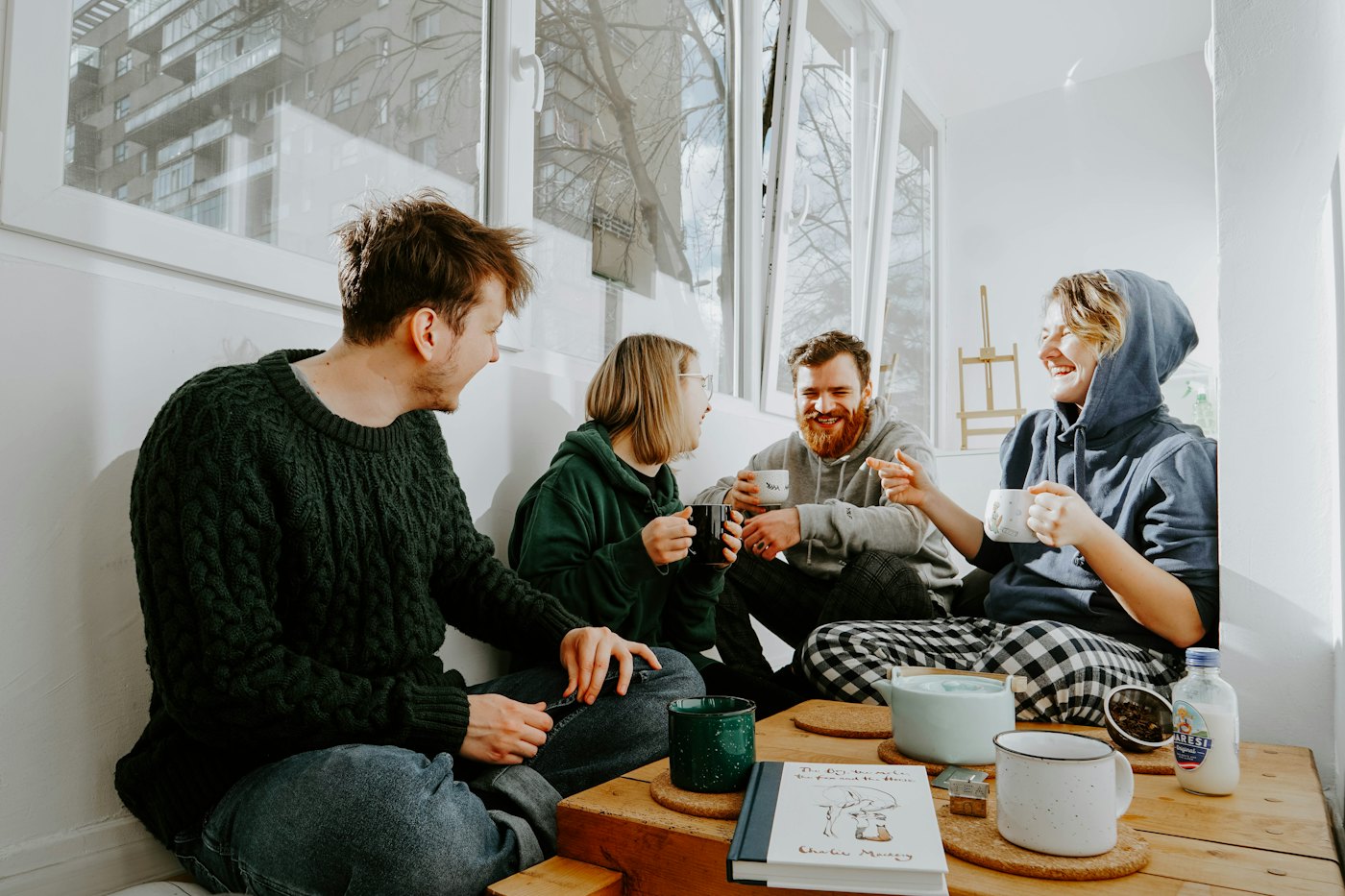 Five friends talking around a wooden café table