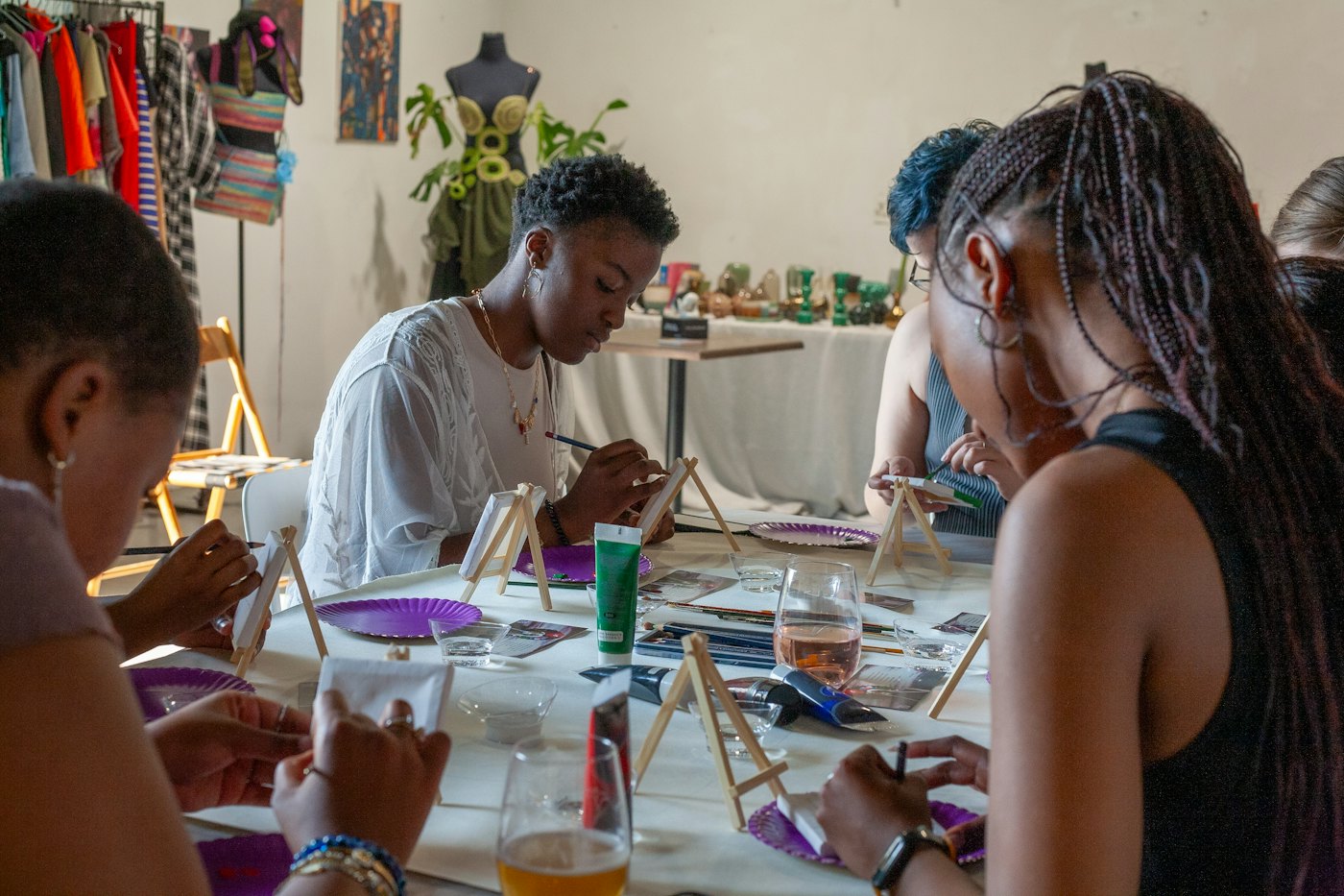 People painting at a long table during an art class